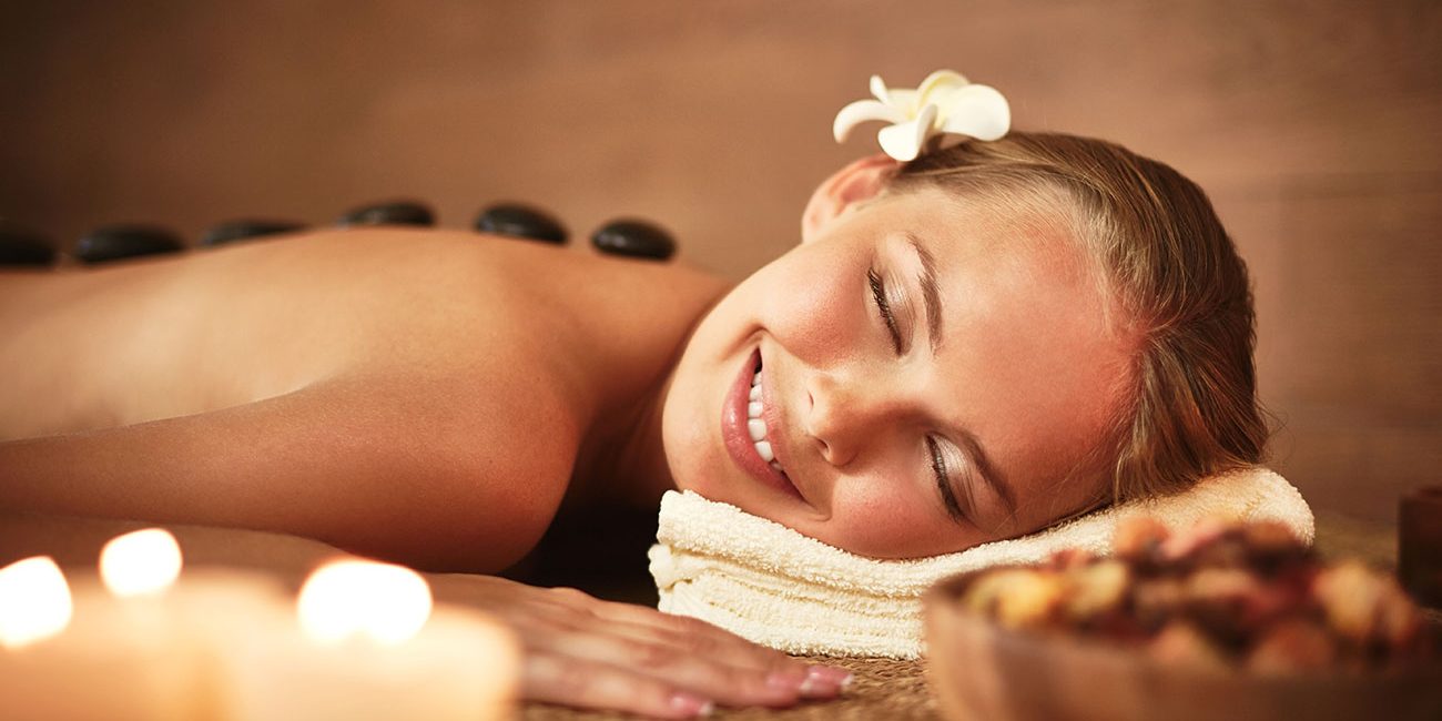 woman-with-closed-eyes-receiving-hot-stone-massage